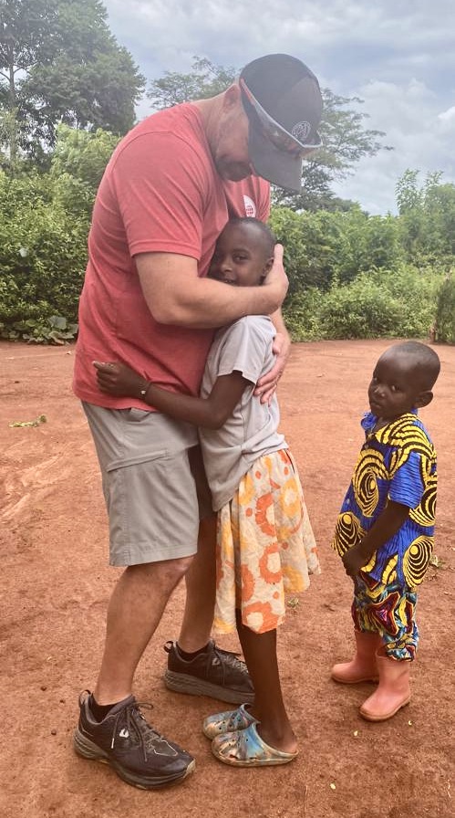 The founder of BUYONE BUILDONE with a child whose home they helped build during a mission trip.