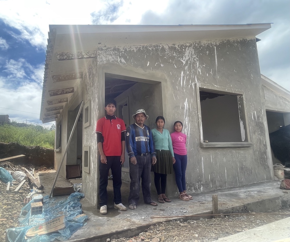 A family standing in front of their house in Bolivia, built by BUYONE BUILDONE.