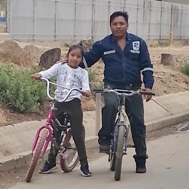A father and daughter riding bikes in Bolivia.